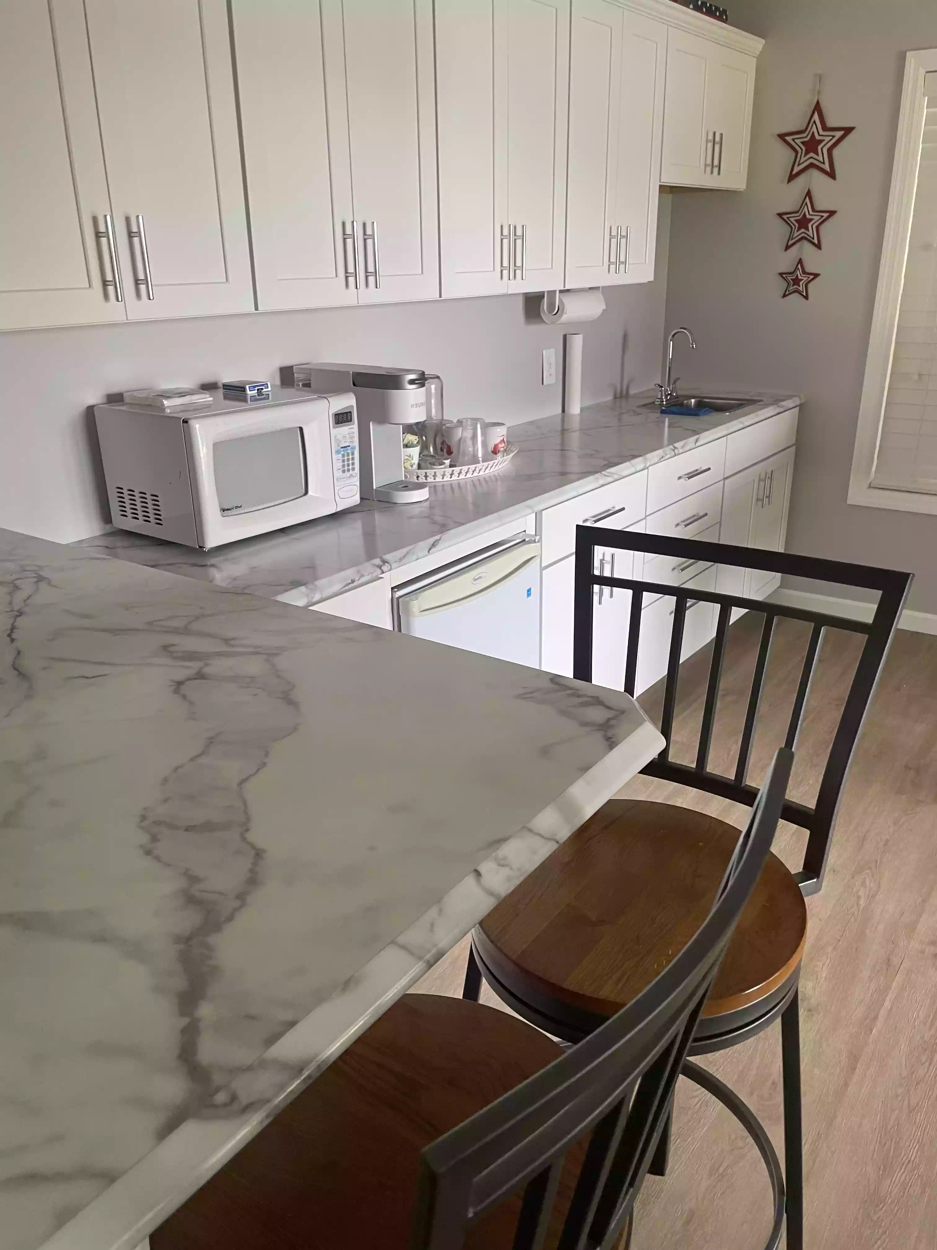 a clean kitchen space featuring shiny marble countertops and organized clean small appliances