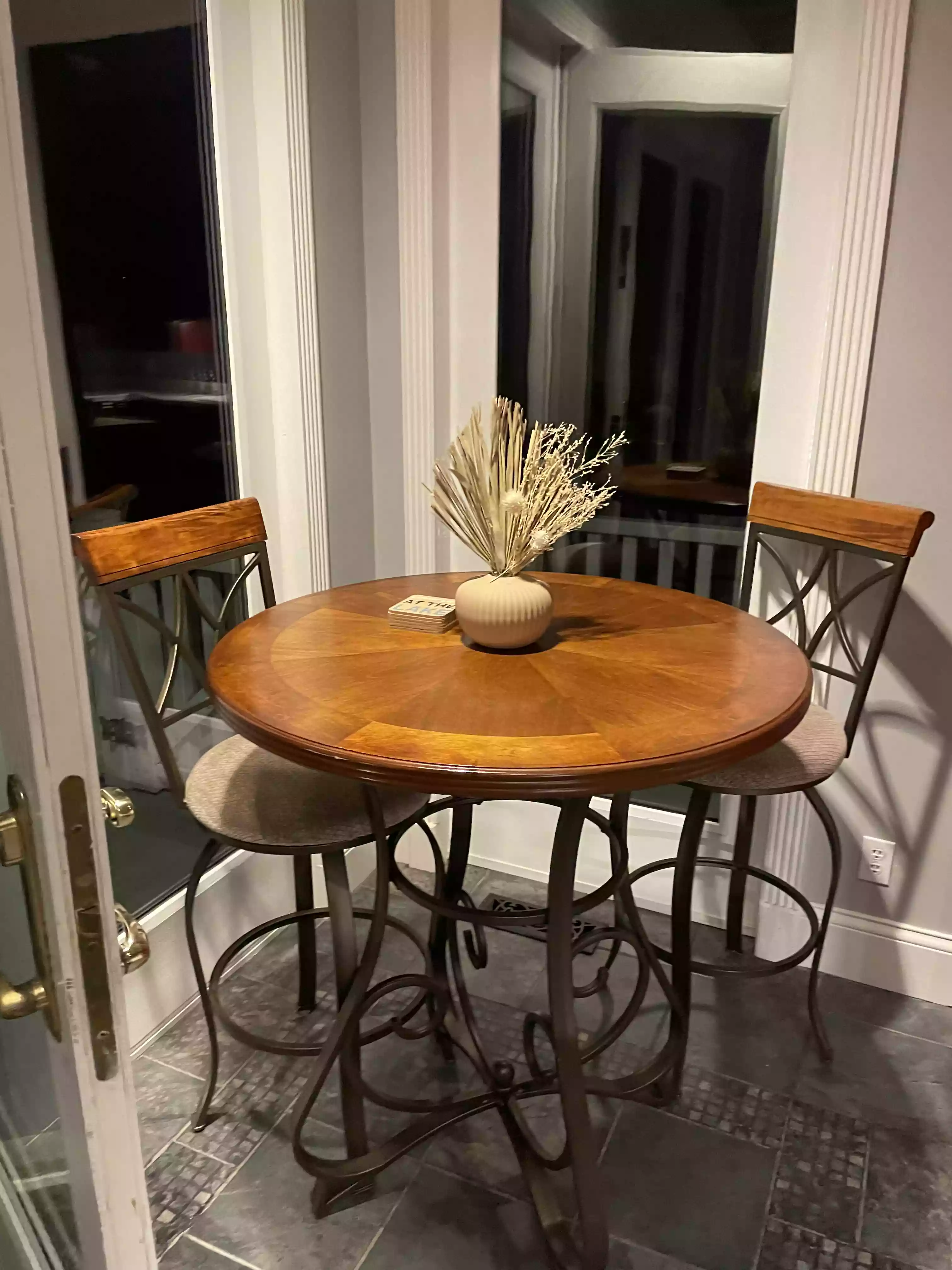 a small, clean dining area featuring a tall table and two chairs