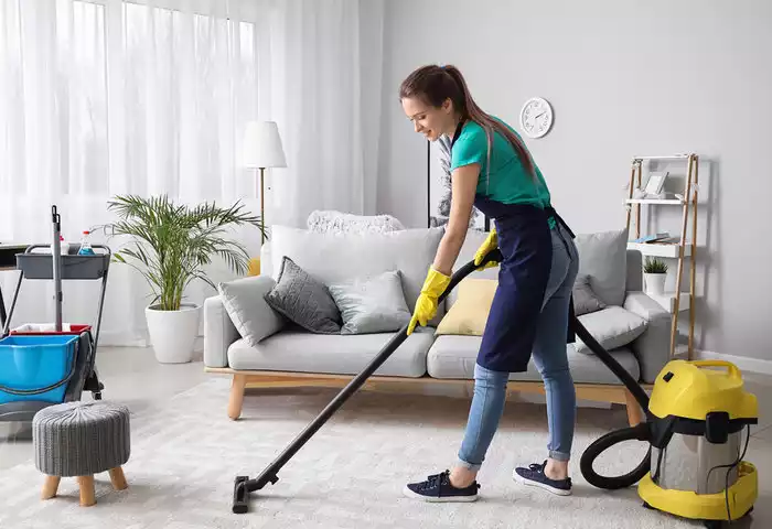 a female cleaner vacuuming a house